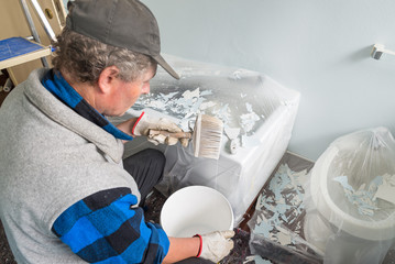 House painter with dripping brush in hand. Home renovation concept