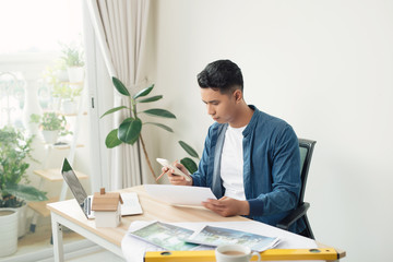 Profile shot of a young male architect working on blueprints at his desk at the office copyspace building plans construction project engineer expert specialist qualified job occupation