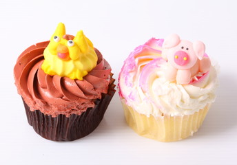 A colorful cupcake with doll on top , isolated