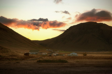 Beautiful golden sunset and big mountain surrounding arround small village in Iceland
