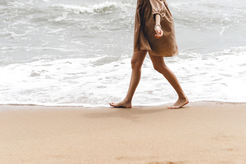 Asian young adult woman walking relax at the beach and open arm hug air.