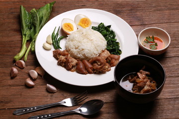 Stewed pork leg on rice on wooden table.Thai food