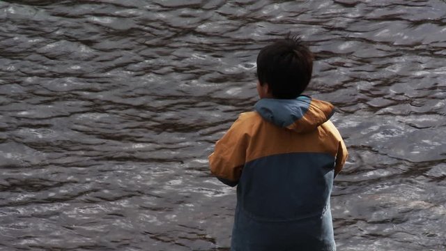 Mapuche Child Engaging With Nature in Patagonia River