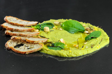 
crackers with cream
 broccoli porridge on a black background