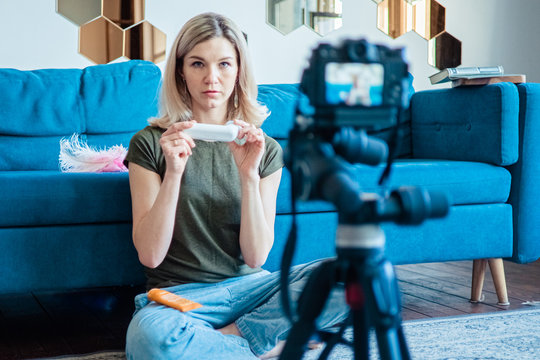 Young woman filming video blog on camera, blogger influencer profession concept