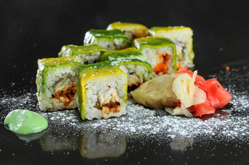sushi rolls with avacado on a black glossy background