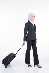 Muslim businesswoman on a business trip, with luggage isolated on white background. Suitable for cut out, manipulation or composite works for travel or business concept. Full length portrait.