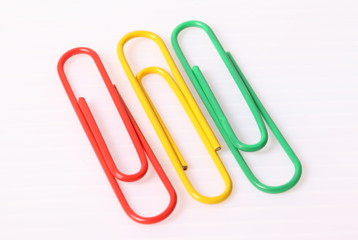 colorful paper clips over the white background