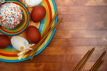 Easter cake with painted eggs on a table made of natural wood.