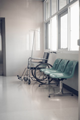 Empty wheelchair and green chairs for patient in the hospital.Medical tool concept.