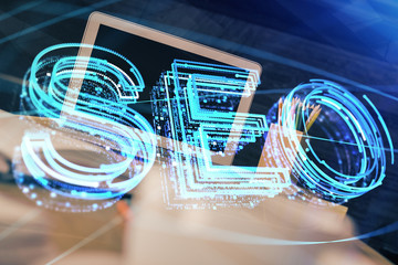 Multi exposure of table with computer and seo drawing hologram. Search optimization concept.