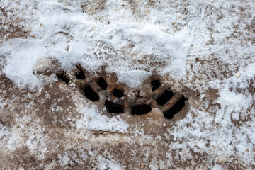 Snow melted around the drain manhole cover.