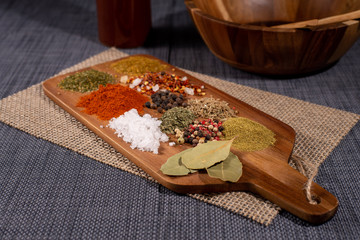 Spices on the kitchen cutting board. Peppers, turmeric, curry, sea salt and bay leaves.