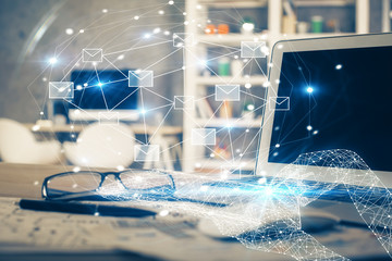 Desktop computer background in office and flying envelops hologram drawing. Multi exposure....