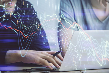 Forex graph with businessman typing on computer in office on background. Concept of analysis. Double exposure.