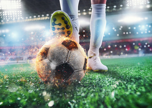 Close up of a soccer striker ready to kicks the fiery ball at the stadium