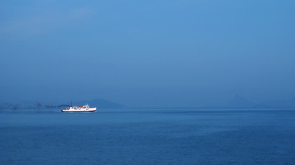 Lonely white ship in the blue sea and blue sky.