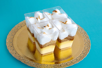 Tasty souffle desserts in a square glass on a blue background