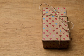 Gift box with hearts for Valentine's day on an old oak table.