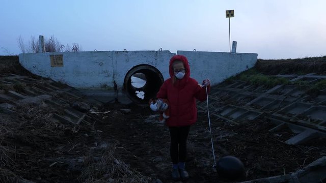 Ditch child in a respirator red jacket with a toy and a black ball, fear and apocarypse, radiation hopelessness