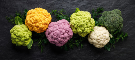 Colorful cauliflowers, fresh colorful cauliflowers on a dark background, top view. Healthy eating