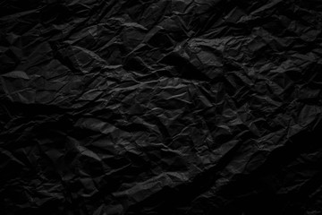 Dark black crumpled paper close up texture background