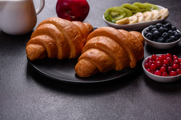 Delicious breakfast with fresh croissants and ripe berries