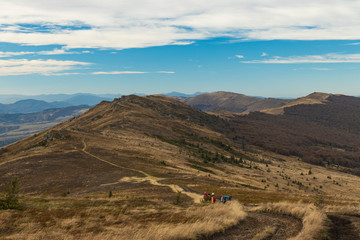 dramatic mountain ridge moody autumn season time soft focus hiking group of people on touristic walking route dirt trail lonely path way with picturesque highland scenic view