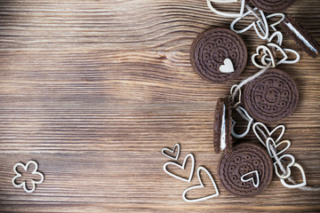 chocolate cookie sandwich on a wooden surface. hearts made of wood are strung on a rope. happy Valentine's day. beautiful picture with biscuits. wooden background. texture.