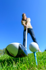 Golferin schlägt einen Ball vom Tee