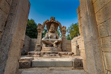 Narsimha Statue. This is the largest statue in Hampi build in 13AC. Narasimha is sitting on the coil of a giant seven-headed snake called Sesha. The heads of the snake act as the hood above his head.