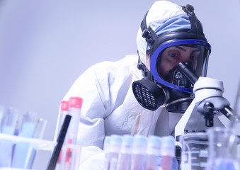 female lab technician doing research in the lab. with gas mask