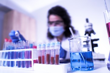 female lab technician doing research with a microscope in the lab.