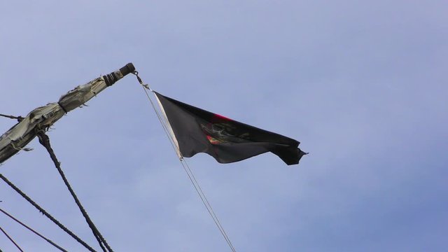 Pirate flag on a pleasure boat evolving against blue sky	