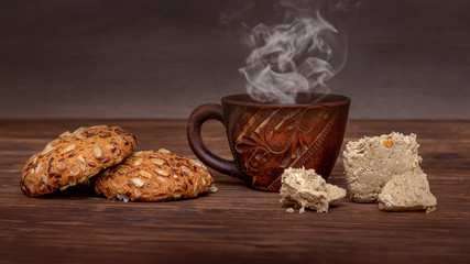 Cup of hot coffee, cookies and halvah on a wooden table_