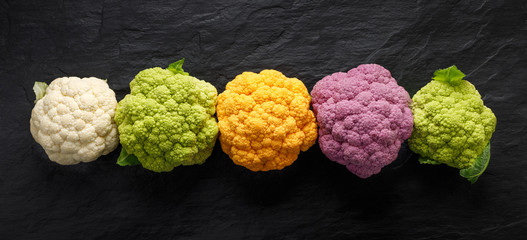 Colorful cauliflowers, fresh colorful cauliflowers on a dark background, top view. Healthy eating