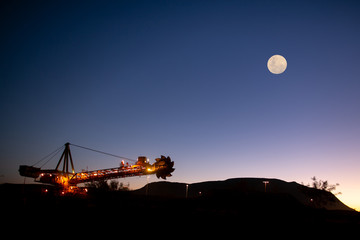 Beautiful isolated massive iron ore reclaimer industry mining heavy duty equipment machinery with...