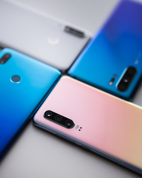 Spiral from colorful modern smartphones isolated in white background. Blue, white and gold phones.