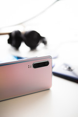 Detailed view of modern pink smartphone. Other blurred phones in background