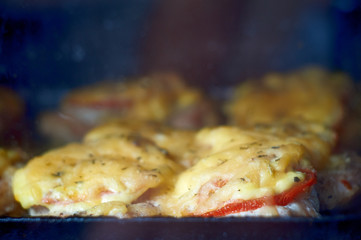 chicken fillet baked in the oven with cheese and tomatoes