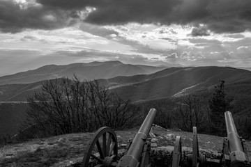 Fototapeta premium Dramatic autumn black and white view over the mountain range from near Shipka peak, Stara Planina mountain in Central Bulgaria as seen from Shipka Memorial. Moody feeling. Old Russian cannon