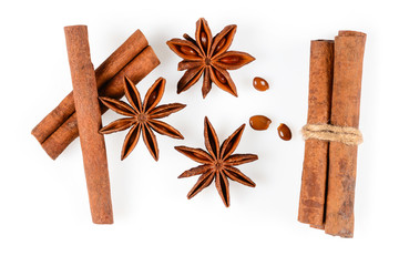 Cinnamon sticks and three anise star spice with seeds. Close up macro isolated on white background with light shadow. Top view, flat lay,