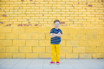 Fototapeta na wymiar Little boy posing against the wall