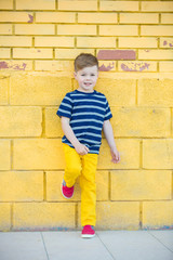 Little boy posing against the wall