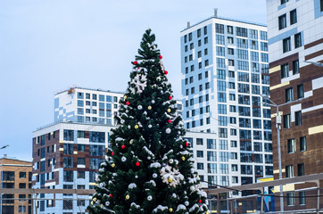 Christmas tree in the courtyard of a high-rise residential complex of increased comfort. Decoration of the public yard for the new year. Modern landscaping of the courtyard of a residential building.