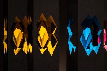 Black paper abstract object with shadows and color inserts. Origami closeup. Graphic neutral...