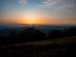 Naklejka na ściany i meble Stoumont, Belgium, 25 January 2020. Sunset over the hills near the Belgian village of Stoumont.