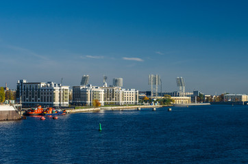 Naklejka premium Sea panorama of the city with blue expanse of water, blue sky. Panorama of the historic city. View of the Petrovsky island of St. Petersburg and the old football stadium