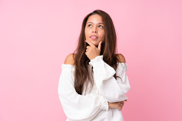 Young Brazilian girl over isolated pink background looking to the side