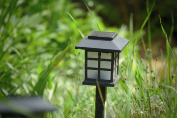Charging solar lamp on the ground in the garden at sunny day, renewable energy concept